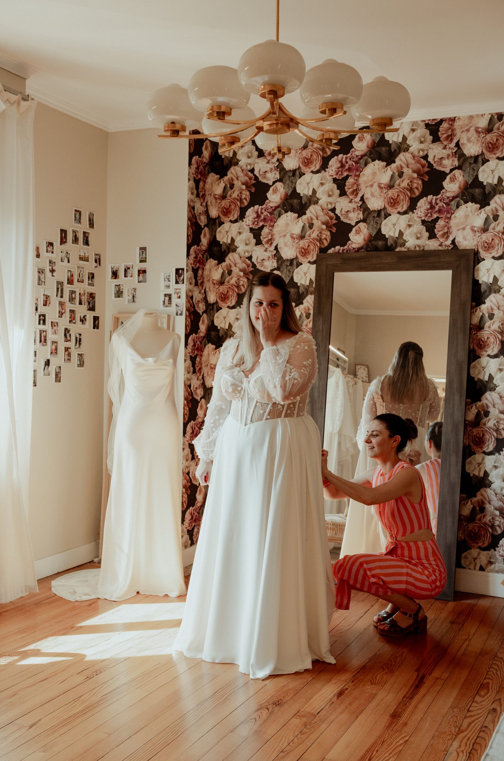 Élodie ajuste la robe de mariée sur mesure d'Emma lors d'un essayage à l'atelier Les Roses de Louise à Toulouse.